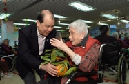 The Secretary for Labour and Welfare, Mr Matthew Cheung Kin-chung, visits the Salvation Army Hoi Tai Residence for Senior Citizens in Mong Kok to extend his Lunar New Year greetings to the elderly. Photo shows Mr Cheung (left) presenting mandarins to the senior residents.