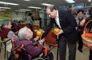 Mr Cheung visits the Salvation Army Hoi Tai Residence for Senior Citizens in Mong Kok to extend his Lunar New Year greetings to the elderly. Photo shows Mr Cheung (right) presenting mandarins to the senior residents.