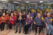 Mr Cheung (front row, third left) is pictured with elderly residents and staff members of the elderly home.