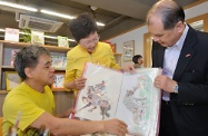 Mrs Lam (second left) and Mr Cheung (first right) being briefed on the daily operation of the Wellness Centre of New Life Psychiatric Rehabilitation Association in Tin Chak Estate.