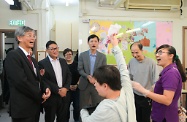 The Secretary for Labour and Welfare, Dr Law Chi-kwong, visited Central and Western District and called at Parkside Residence and Parkside Integrated Service Team operated by St James' Settlement Rehabilitation Services in Sai Ying Pun. Photo shows Dr Law (first left) and the Chairman of the Central and Western District Council, Mr Yip Wing-shing (second left), watching a person with intellectual disability performing.