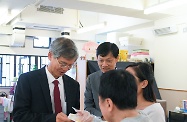 The Secretary for Labour and Welfare, Dr Law Chi-kwong, visited Central and Western District and called at Parkside Residence and Parkside Integrated Service Team operated by St James' Settlement Rehabilitation Services in Sai Ying Pun. Photo shows a person with disability sharing handmade cookies with Dr Law (left).