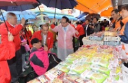 Mr Cheung (third left) accompanies a person with disabilities in shopping around the fair.