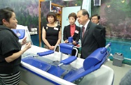 Mr Cheung is briefed on the facilities by the staff of the home for the elderly.