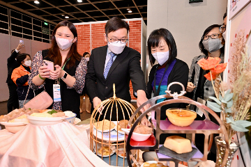 The Secretary for Labour and Welfare, Mr Chris Sun, attended a forum on 'Tech-enhanced Social Care - the Way Ahead after the Pandemic' this morning (November 4) at the Gerontech and Innovation Expo cum Summit 2022 jointly hosted by the Government and the Hong Kong Council of Social Service. Photo shows Mr Sun (third right) and the Director of Social Welfare, Miss Charmaine Lee (second right), learning more about the soft meals and cooking methods catering for the needs of persons with swallowing difficulties at the Care Food Pavilion.