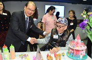 The Secretary for Labour and Welfare, Mr Matthew Cheung Kin-chung, today attended the opening ceremony of Po Leung Kuk Wan Chai Home for the Elderly cum Day Care Centre for the Elderly. Photo shows Mr Cheung (left) shaking hands with an elderly participant.