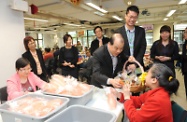 张建宗（左五）与在工场接受训练的残疾人士倾谈后，向他们送上食品礼包，和大家预庆新春。