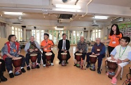 The Secretary for Labour and Welfare, Dr Law Chi-kwong, visited Tai Po District and elderly residents in TWGHs Pao Siu Loong Care & Attention Home. Photo shows Dr Law (centre) playing African drums with the elderly.