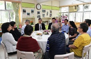 The Secretary for Labour and Welfare, Dr Law Chi-kwong, visited Tai Po District and elderly residents in TWGHs Pao Siu Loong Care & Attention Home. Photo shows Dr Law (centre) discussing the small group unit model of the institution with residents and their families.