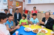 张建宗（右一）与家舍的宿生分享小食。后排左一为劳工及福利局副局长萧伟强。
