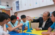 Mr Cheung (second right) plays a game with residents of the home and a house parent (third left). He thanked the house parent and her family for their commitment in providing a home-like environment for the healthy growth of children in need.