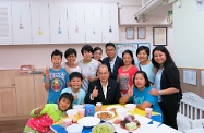 Mr Cheung (second right, front row) is pictured with residents and staff of the Home, as well as the house parents and their family.