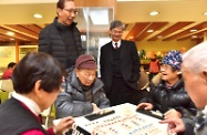 The Secretary for Labour and Welfare, Dr Law Chi-kwong, visited Caritas Cheng Shing Fung District Elderly Centre (Sham Shui Po). Photo shows Dr Law (right), accompanied by the Senior Social Work Supervisor of Services for the Elderly of Caritas Hong Kong, Mr Lai Sau-man (left), watching elderly people playing a board game.