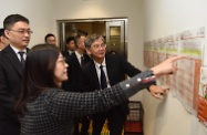 The Secretary for Labour and Welfare, Dr Law Chi-kwong, visited the Working Family Allowance Office for an update on the improved Working Family Allowance Scheme to be implemented on April 1. Photo shows the Head of the Working Family and Student Financial Assistance Agency, Mr Esmond Lee (left), accompanying Dr Law (right) to view posters in various languages for people from ethnic minorities to understand the scheme arrangements.