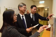 The Secretary for Labour and Welfare, Dr Law Chi-kwong, visited the Working Family Allowance Office for an update on the improved Working Family Allowance Scheme to be implemented on April 1. Photo shows Dr Law (centre) and the Under Secretary for Labour and Welfare, Mr Caspar Tsui (right), viewing leaflets in various languages for people from ethnic minorities to understand the scheme arrangements.