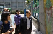 Mr Cheung (right) looks at a mosaic picture done by those serving community service orders in Ma On Shan Ling Liang Primary School. Accompanying Mr Cheung was the school principal, Ms Chan May-kuen (second right).