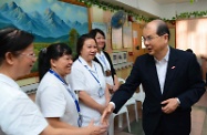 Mr Cheung (first right) talks to workers of the home to hear about the training in care skills they received.