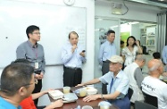 Mr Cheung (second left) chats with diners at the canteen on their needs and briefs them on new measures for the benefit of the public announced in the past two months.