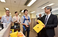 The Secretary for Labour and Welfare, Dr Law Chi-kwong, visited the Labour Department (LD) Headquarters to take a closer look at its work. Photo shows Dr Law (first right) being briefed on the LD's stepped up education and publicity on safety for working at height and in construction sites.