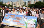 Mr Cheung with other officiating guests and the Mental Health Ambassadors leads the participants of the Mental Health Walk to start off from the soccer pitch at Victoria Park.