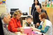 Mr Cheung accompanies Her Majesty Queen Mathilde to observe a child receiving speech training in the centre.