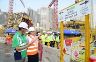 Mr Cheung (second left) inspects the multi-language safety signage in the construction site.