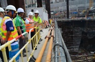 Mr Cheung (second right) is briefed by the contractor on the OSH measures implemented in the site's excavation and blasting work.