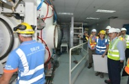 張建宗（前右）聽取有關工人在高壓裝置及設備工作時所採取的職業安全健康措施。