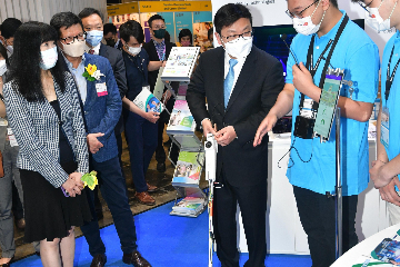 The Secretary for Labour and Welfare, Mr Chris Sun, officiated at the opening ceremony of the Hong Kong Trade Development Council Education & Careers Expo 2022 today (July 21). Photo shows Mr Sun (centre) at the Vocational Training Council booth, using a Smart Cane 