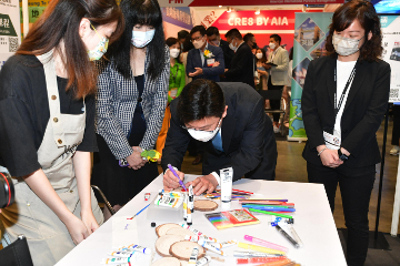 劳工及福利局局长孙玉菡今日（七月二十一日）主持香港贸易发展局「教育及职业博览2022」开幕礼。图示孙玉菡（右二）在香港青年协会的摊位制作纪念品，为青年打气。