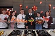 The Secretary for Labour and Welfare, Dr Law Chi-kwong, visited M21 Kitchen of the Hong Kong Federation of Youth Groups and took part in video-shooting for its "Neighbourhood First" programme. Photo shows Dr Law (third right) extending early Lunar New Year greetings with a young chef and youth volunteers.