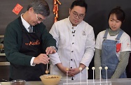 The Secretary for Labour and Welfare, Dr Law Chi-kwong, visited M21 Kitchen of the Hong Kong Federation of Youth Groups and took part in video-shooting for its "Neighbourhood First" programme. Photo shows Dr Law (left) preparing dessert with care.