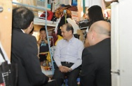 Mr Cheung (centre) visits a new arrival family of five at a cubicle apartment to hear the views of the grass roots.