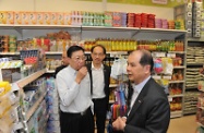 Mr Cheung (right) visits the HOME Market of the New Home Association where he is briefed by the Director of Loving Home Foundation Limited, Mr Suen Kwok-lam (left), on the convenience store's operation.