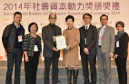 Mrs Lam (centre), presenting the Outstanding Social Capital Partnership Award to representatives of an enterprise awardee at the Social Capital Builder Award Presentation Ceremony.