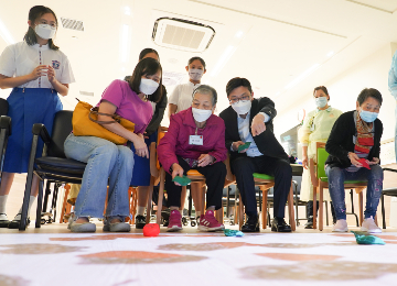 The Secretary for Labour and Welfare, Mr Chris Sun, visited elderly community care and After School Care Programme service centres on September 16 to keep abreast of care services for the young and old. Photo shows Mr Sun (front row, second right) in an interactive training game with elderly people and student volunteers at Lok Sin Tong Biu Chun Day Care Centre for the Elderly.