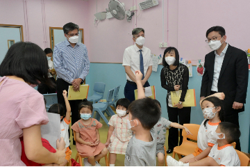 The Secretary for Labour and Welfare, Mr Chris Sun, visited elderly community care and After School Care Programme (ASCP) service centres on September 16 to keep abreast of care services for the young and old. Photo shows Mr Sun (back row, first right), accompanied by the Director of Social Welfare, Miss Charmaine Lee (back row, second right), watching pre-primary children attending the ASCP at Chinese Evangelical Zion Church Grace After School Care Centre for Pre-primary Children.