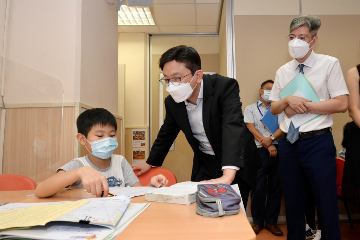 The Secretary for Labour and Welfare, Mr Chris Sun, visited elderly community care and After School Care Programme (ASCP) service centres on September 16 to keep abreast of care services for the young and old. Photo shows Mr Sun (centre) chatting with a student attending the ASCP for primary school students at Chinese Evangelical Zion Church Tsz Wan Shan Zion Children and Youth Integrated Services Centre.