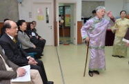 Mr Cheung (left) enjoys a drama performance by elderly members.