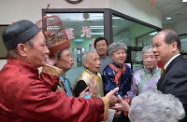 Mr Cheung (right) chats with members of the centre's drama club and praises them for fully demonstrating the spirit of "fostering a sense of worth among the elders" and "active ageing".