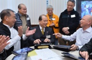 Mr Cheung (third left) plays a song with elderly members using tablet computers.