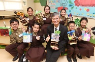 The Secretary for Labour and Welfare, Dr Law Chi-kwong, visited Wong Tai Sin District and called at Canossa Primary School (San Po Kong). Photo shows Dr Law (front row, centre) with students and some of their work.