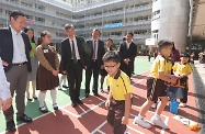 The Secretary for Labour and Welfare, Dr Law Chi-kwong, visited Wong Tai Sin District and called at Canossa Primary School (San Po Kong). Photo shows Dr Law (third left) and the Under Secretary for Labour and Welfare, Mr Caspar Tsui (first left), accompanied by the Chairman of the Wong Tai Sin District Council, Mr Li Tak-hong (first right); the Supervisor of Canossa Primary School (San Po Kong), Ms Yuen Wai-ching (second right); and the Principal, Mr Charley Chan (third right), touring the campus and chatting with students.