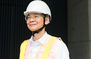 勞工及福利局局長羅致光博士示範使用安全帽連Y型帽帶、反光衣及梯台等高處工作安全裝備。