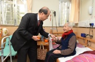 劳工及福利局局长张建宗（左）大年初四上午到访位于鸭洲利东的香港基督教女青年会郑傍卿护理安老苑。他向一位102岁的人瑞院友送上甜柑，祝她身体健康，龙马精神。