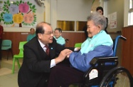 Mr Cheung (left) chats with an elderly resident, aged 102, and wishes her good health.