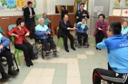 Mr Cheung (front row, third left) joins elderly residents in a physical exercise session.