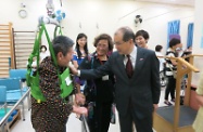 Mr Cheung (second right) chats with an elderly resident in a physiotherapy session.