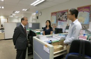 Mr Cheung (first left) talks with staff of the Minimum Wage Commission secretariat and encourages them to keep up their good work.