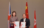 Mr Cheung (right) and Ms Wilson exchange official letters on the agreement to establish the Working Holiday Scheme.